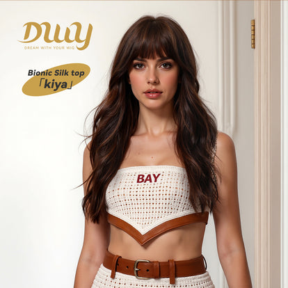 A product photograph of a woman with long, wavy, dark brown hair and bangs wearing a crocheted crop top and a matching belt, all by the DWY brand. The top features brown leather trim and the word 'BAY' in red text. In the top-left corner, the DWY logo and a product information tag reading 'Bionic Silk top 「kiya」' are displayed against a plain background.