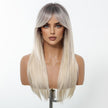 A female mannequin head displays a long, straight DWY wig featuring a trendy root-smudge effect, transitioning from dark roots to a bright platinum blonde. The wig includes full, sweeping curtain bangs.