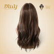 A back view of a mannequin head displaying a long, wavy brown wig with subtle highlights. The DWY brand logo is in the upper left, and a Muse Design Awards winner logo is in the upper right. The background is a soft, light beige studio setting.