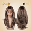 A double-view product shot of a female mannequin head displays a DWY brand synthetic wig. The wig features long, layered brown hair with blonde highlights and a full fringe. Both front and back views are shown against a beige background with the gold 'DWY DREAM WITH YOUR WIG' logo and a 'MUSE DESIGN AWARDS' badge.