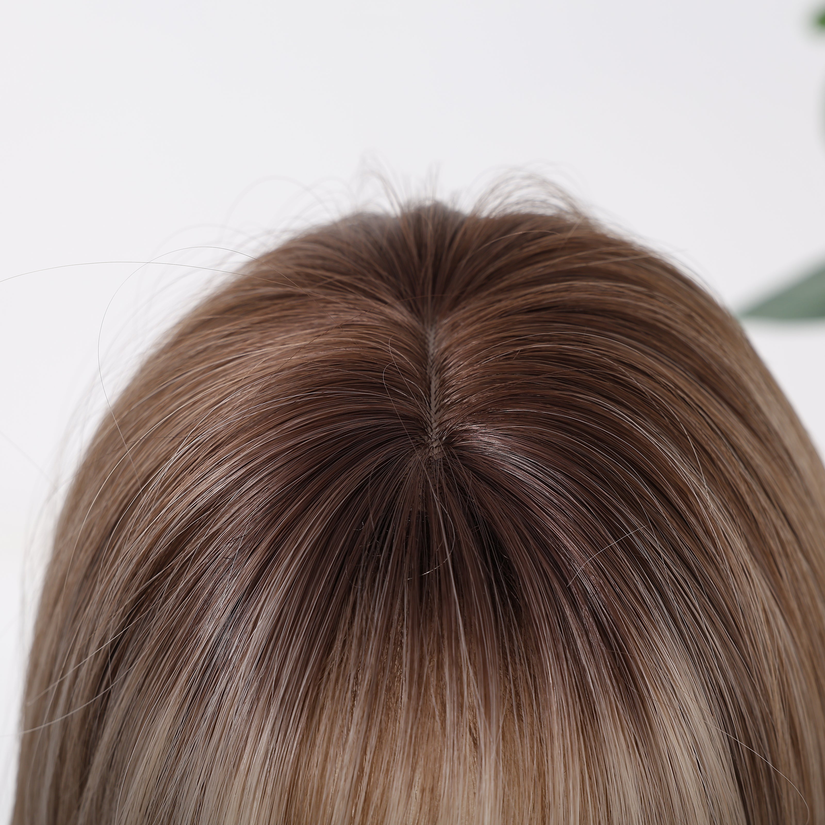 Close-up view of a mixed dark blonde bob wig showing a realistic scalp area, natural-looking hair roots, and a seamless parting design for a more lifelike and elegant wig appearance.