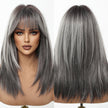 A studio product shot featuring a realistic female mannequin head displaying a medium-length, layered synthetic wig in a two-view layout. The left side shows the front view of the mannequin with full makeup, blue eyes, and the wig's face-framing bangs and layers, colored with dimensional dark roots blending into cool silver-grey highlights. The right side presents the back view, highlighting the shoulder-length cut, texture, and color distribution. Both views are set against a clean white background.