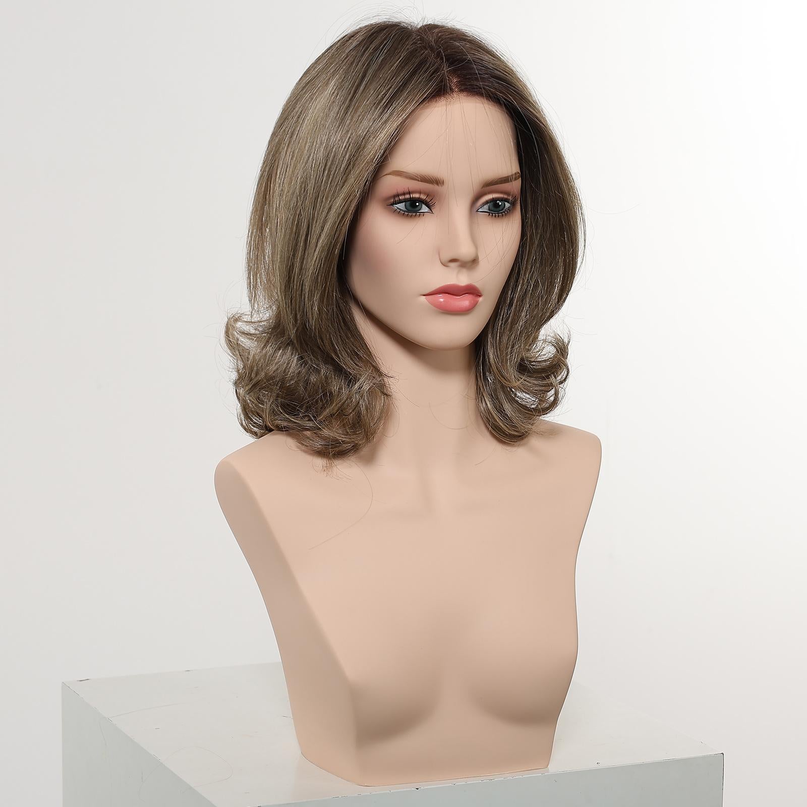 A realistic female mannequin head, set against a plain white studio background, displays a medium-length DWY wig. The layered hair is a blend of dark brown and ash brown, styled with a central part and flipped-out, voluminous curls at the ends. The mannequin wears subtle makeup and is positioned from a 3/4 view.